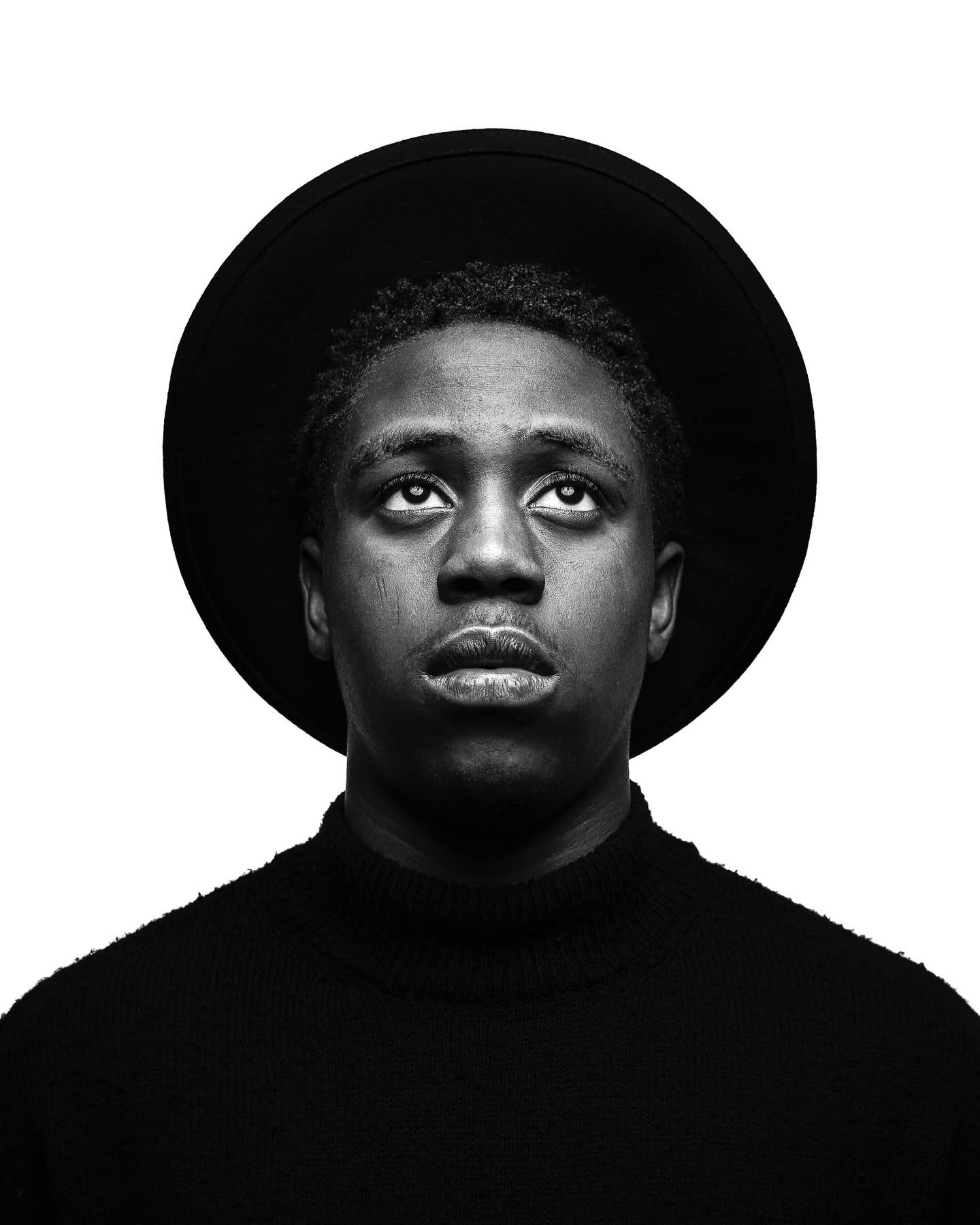 Black and white portrait of a young man wearing a hat